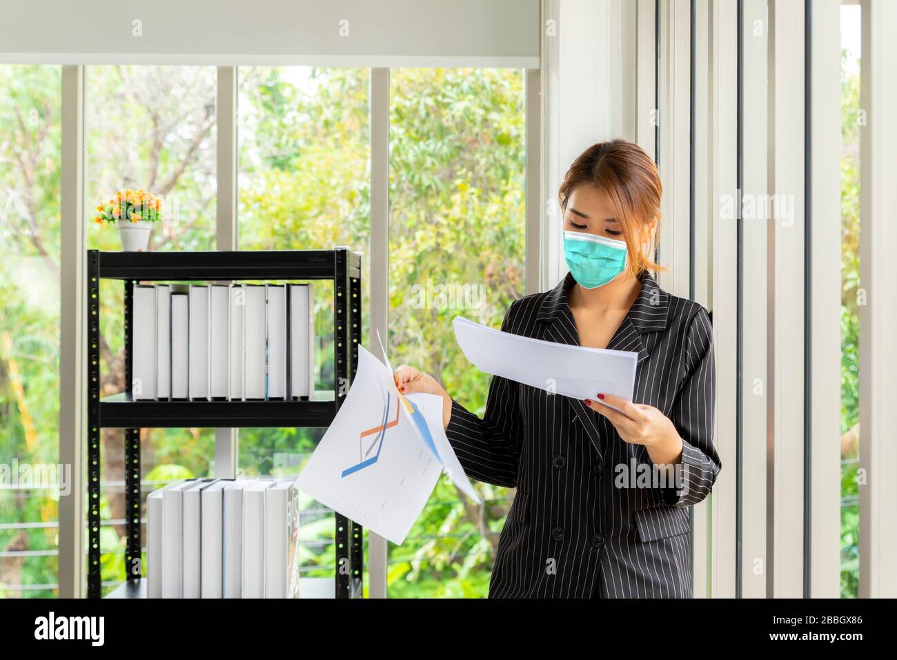 Geschäftsfrau, die von zu Hause aus mit Schutzmaske arbeitet. Selbstquarantäne 14 Tage für Coronavirus. Stockfoto