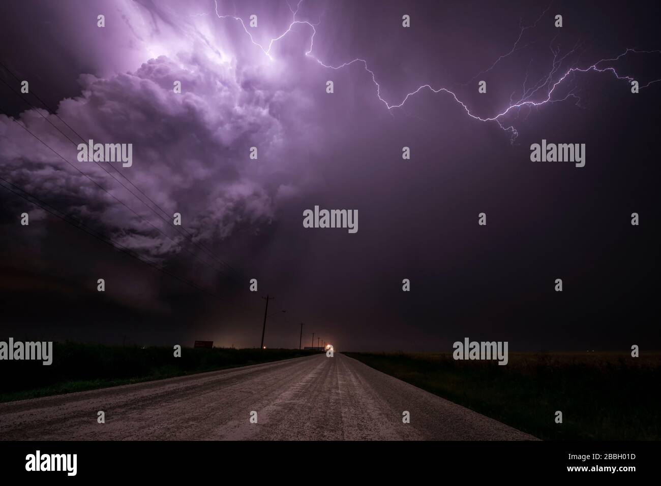 Sturm mit Blitzschlag über Schotterstraße im ländlichen Süden Manitobas Kanadas Stockfoto