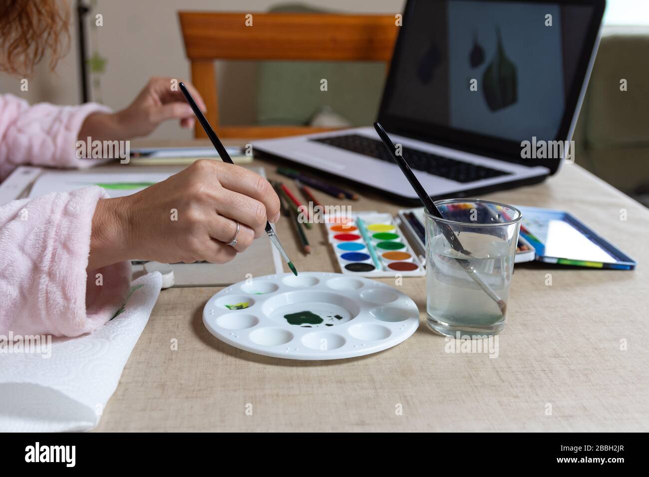 Frau, die einen Online-Kurs in Aquarellmalerei, Unterhaltung gegen die Einschließung von Coranavirus macht Stockfoto