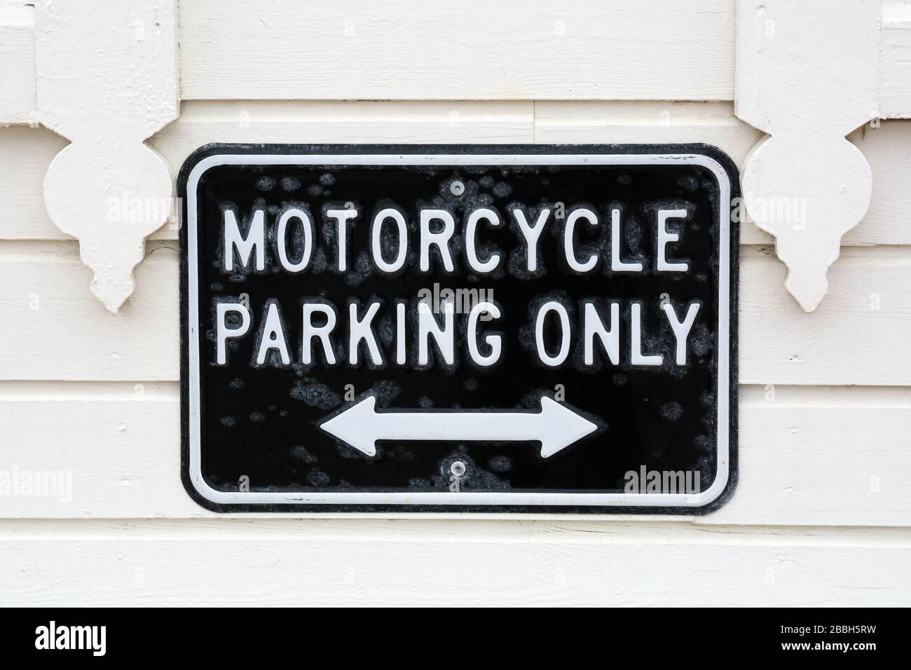 Motorradparkplätze nur vor dem Hintergrund einer weißen Holzwand Stockfoto