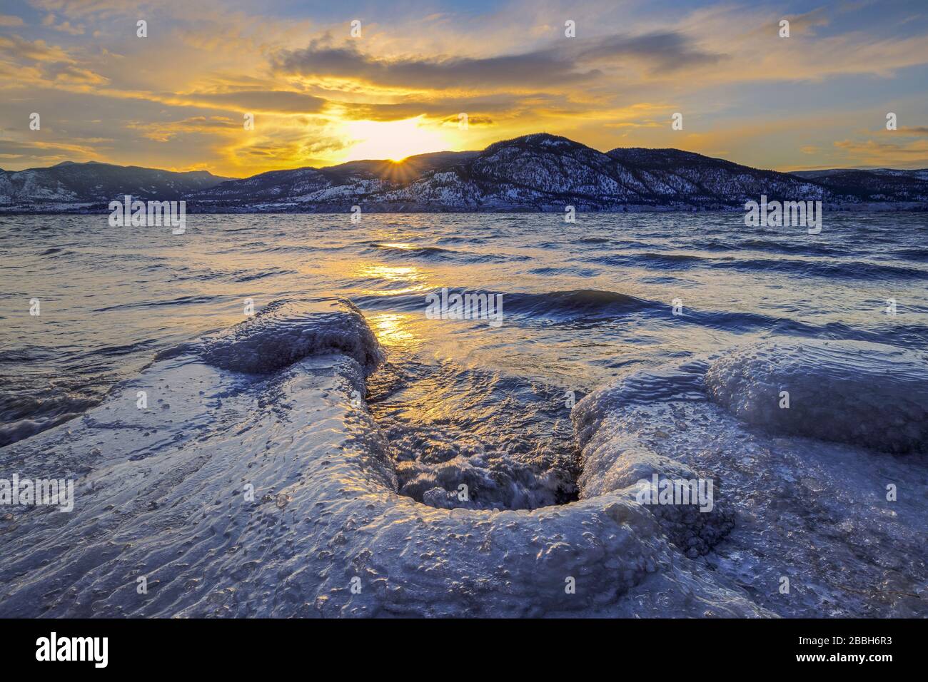 Im Winter geht die Sonne hinter den Bergen über den Okanagan Lake. Penticton, British Columbia, Kanada. Stockfoto