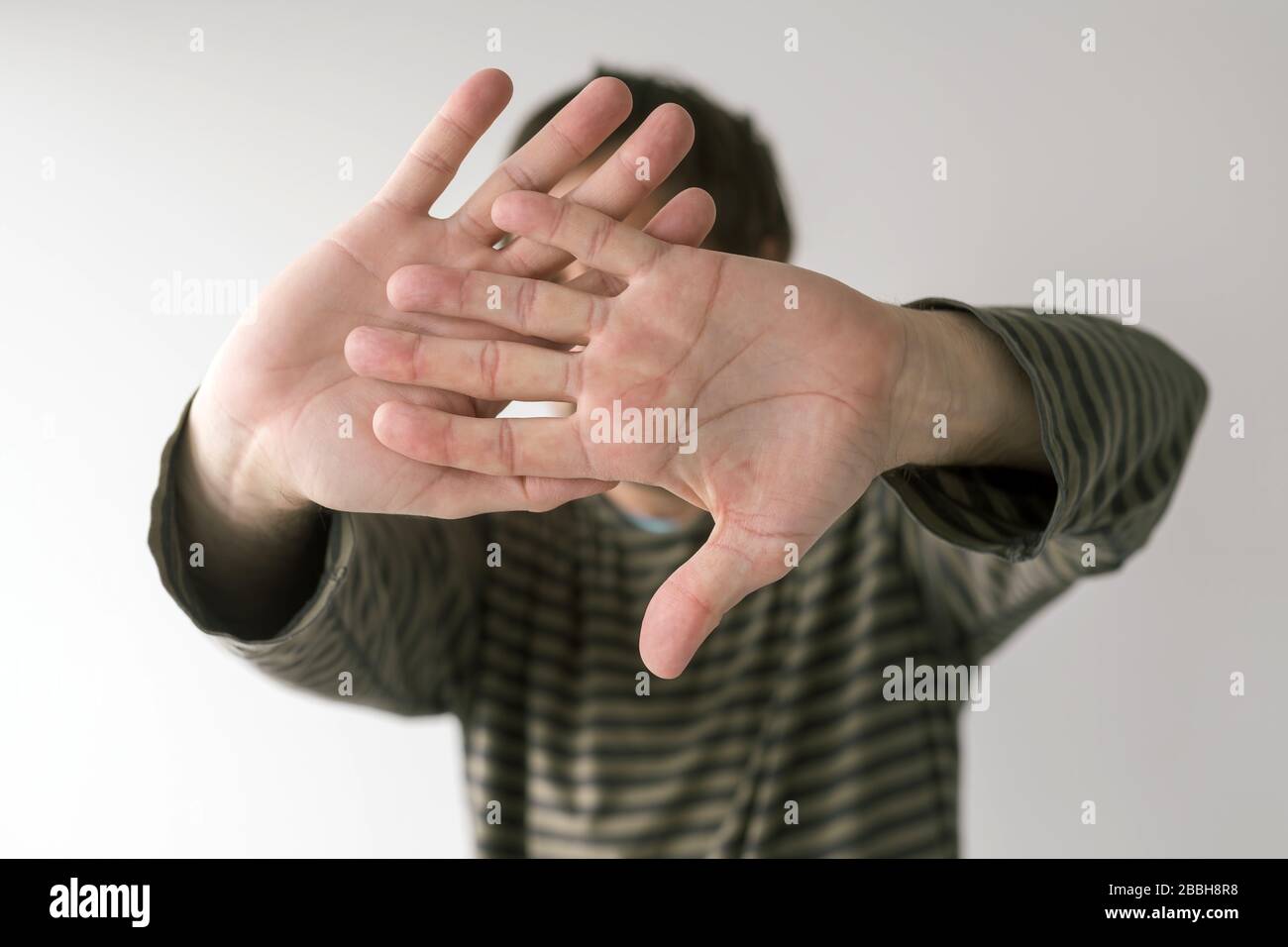 Soziale Distanzierung beim Virus-Outbreak-Konzept, gestirmtes Stoppschild, selektiver Fokus auf die Hände Stockfoto