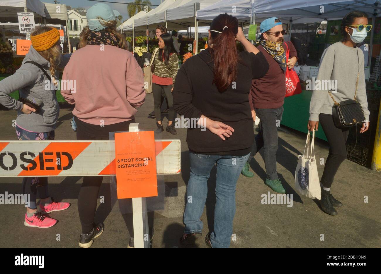 Die Marktkäufer der Farmer können keine soziale Distanzierung von 6' beibehalten, die auf den Schildern auf dem Larchmont Village Market in Los Angeles am Sonntag, 29. März 2020 empfohlen wird. Bürgermeister Eric Garcetti sagte in seinen fortgesetzten Bemühungen, die Menschenmassen inmitten des städtischen und landesweiten Aufenthalts zu Hause zu kontrollieren, dass die Bauernmärkte vorübergehend geschlossen werden und nur dann wieder geöffnet werden dürfen, wenn sie einen Plan vorlegen, der zeigt, wie Menschenmassen kontrolliert werden können. Garcetti sagte, dass dies unter anderem bedeuten könnte, dass man einen einzigen Eintrag und einen einzigen Ausstieg verlangen muss. Dateifoto von Jim Ruymen/UPI Stockfoto