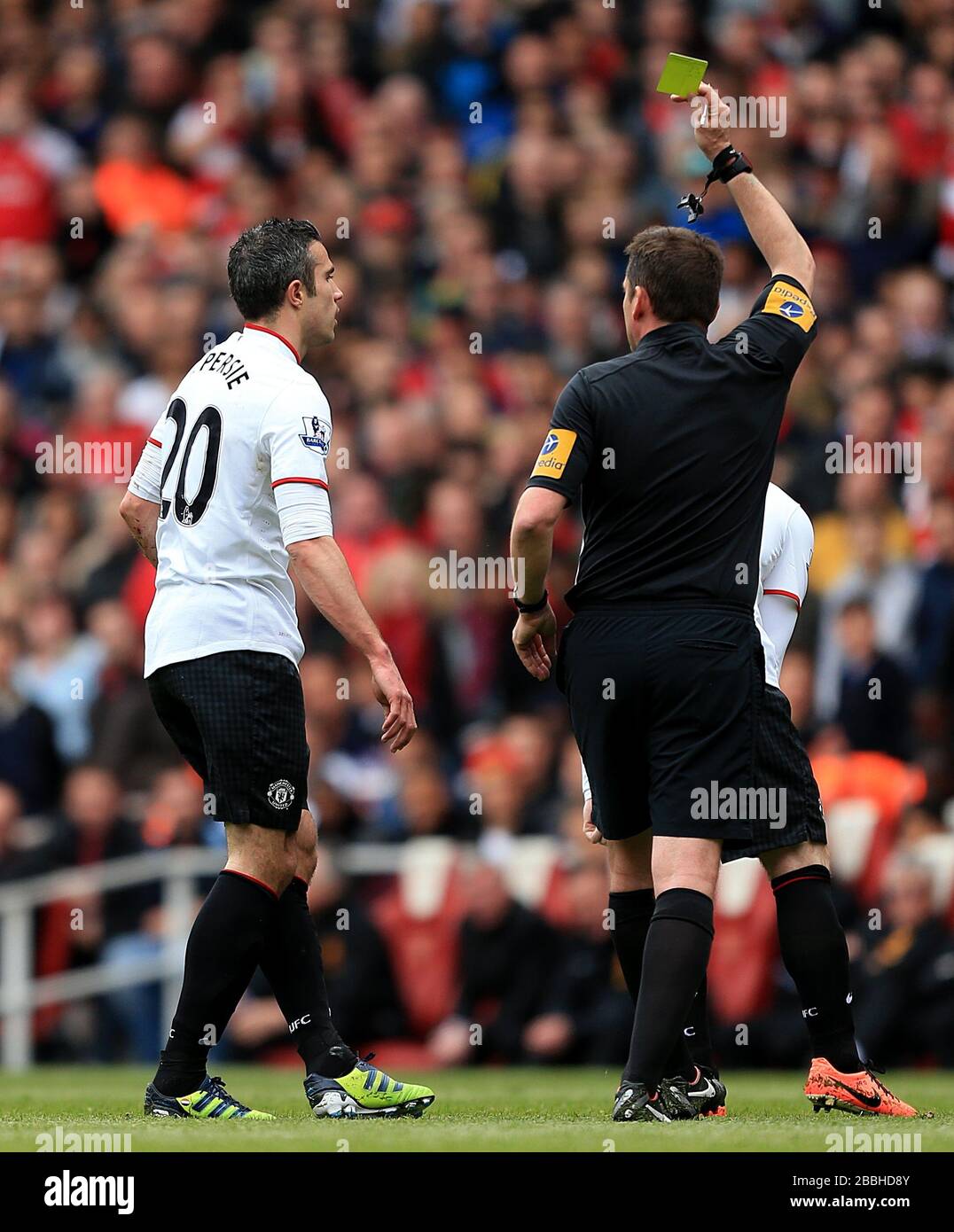 Robin van Persie (links) von Manchester United wird vom Schiedsrichter Phil Dowd nach seiner Aufgabe auf Arsenals per Mertesacker eine gelbe Karte gezeigt Stockfoto