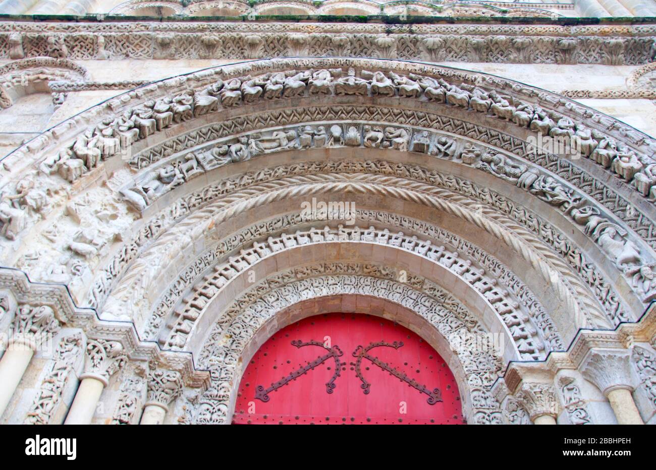 Geschnitzter Zierbogen über der roten Eingangstür der Kirche. Bordeaux, Frankreich Stockfoto