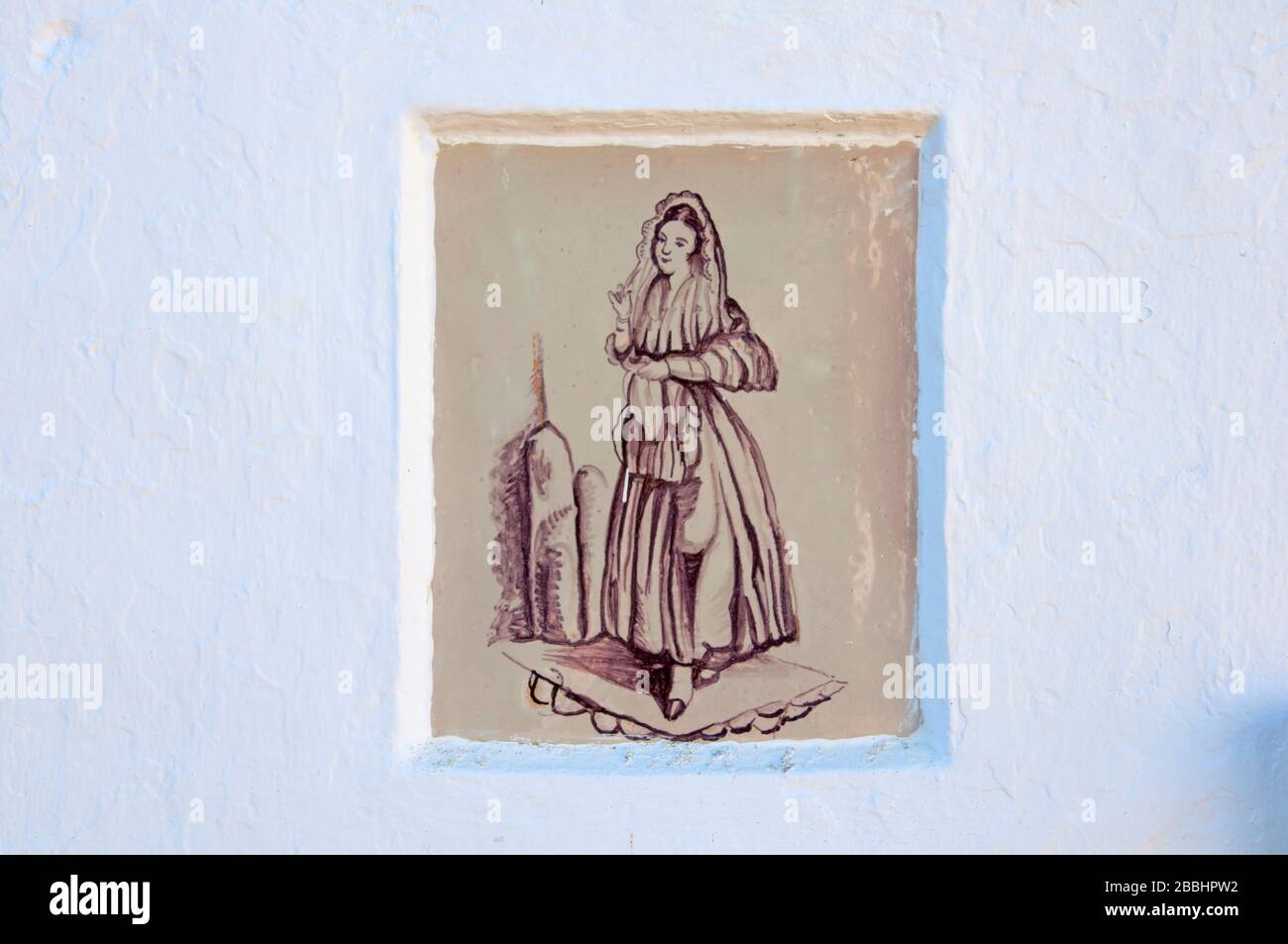 Spanisches Kacheln mit dem Frauenbild an der weißen Wand, pastellbraune Farben. Stockfoto