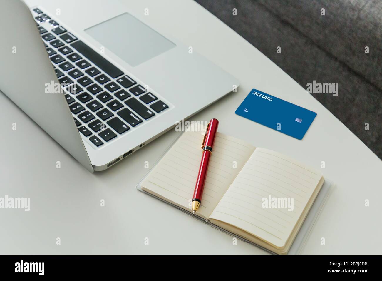 Online-Shopping-Konzept mit Laptop, Kreditkarte und Notebook für Einkaufsliste. Stockfoto