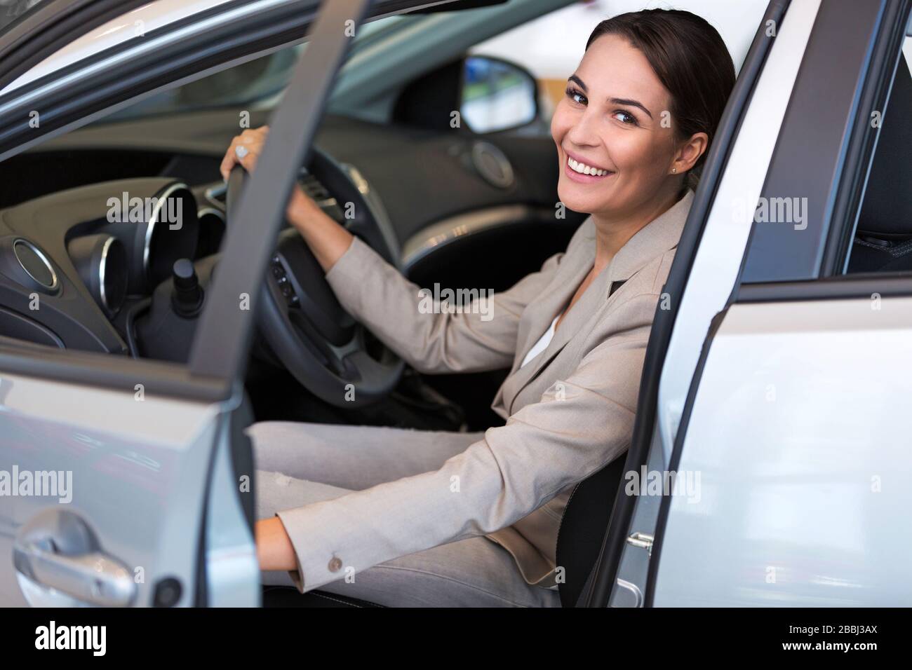 Junge Frau im Autoshowroom Stockfoto