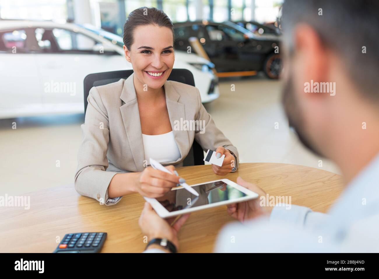 Junge Frau im Autoshowroom Stockfoto