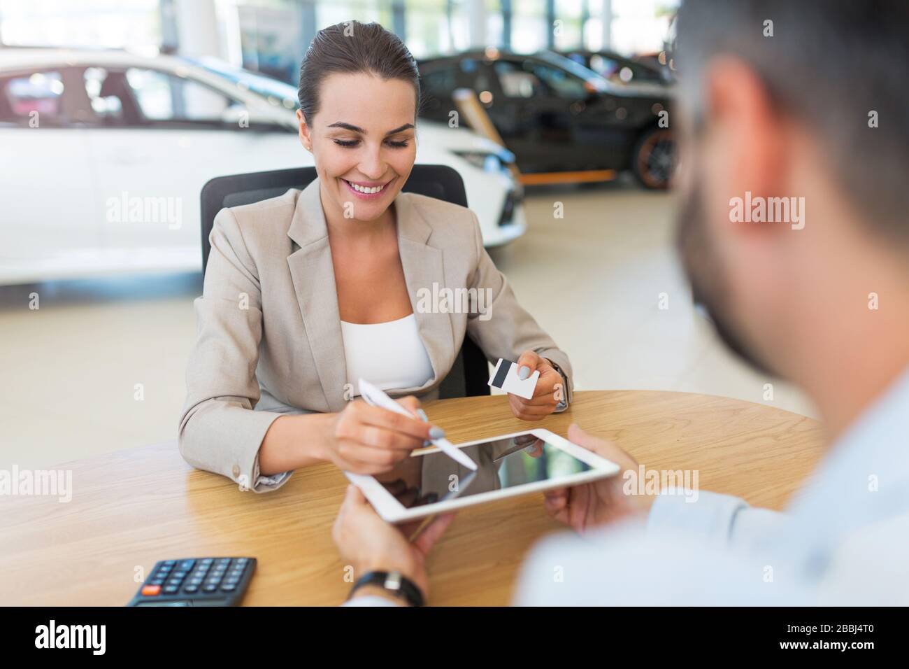 Junge Frau im Autoshowroom Stockfoto