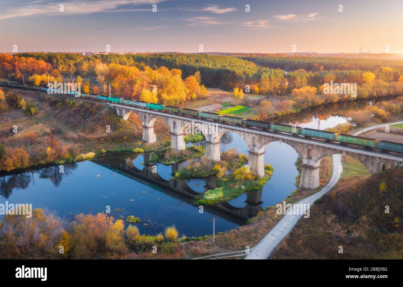 Luftbild des Güterzugs auf Eisenbahnbrücke und Fluss Stockfoto