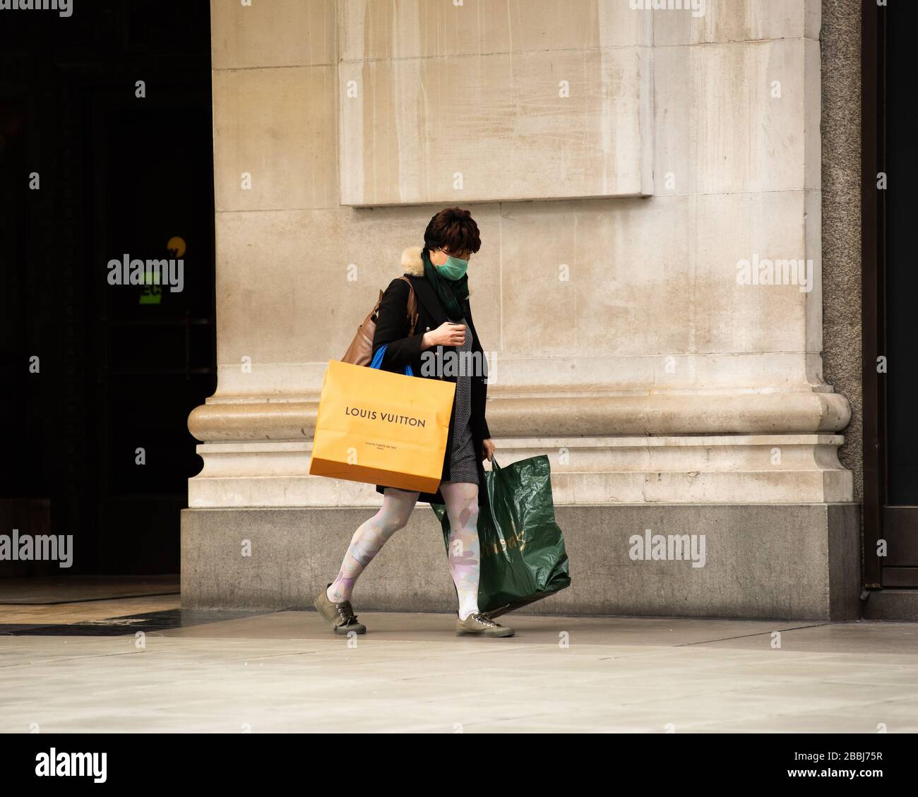 Eine Frau, die Gesichtsmaske trägt, während der Sperrung des Corona-Virus in London, England, einkaufen. Stockfoto