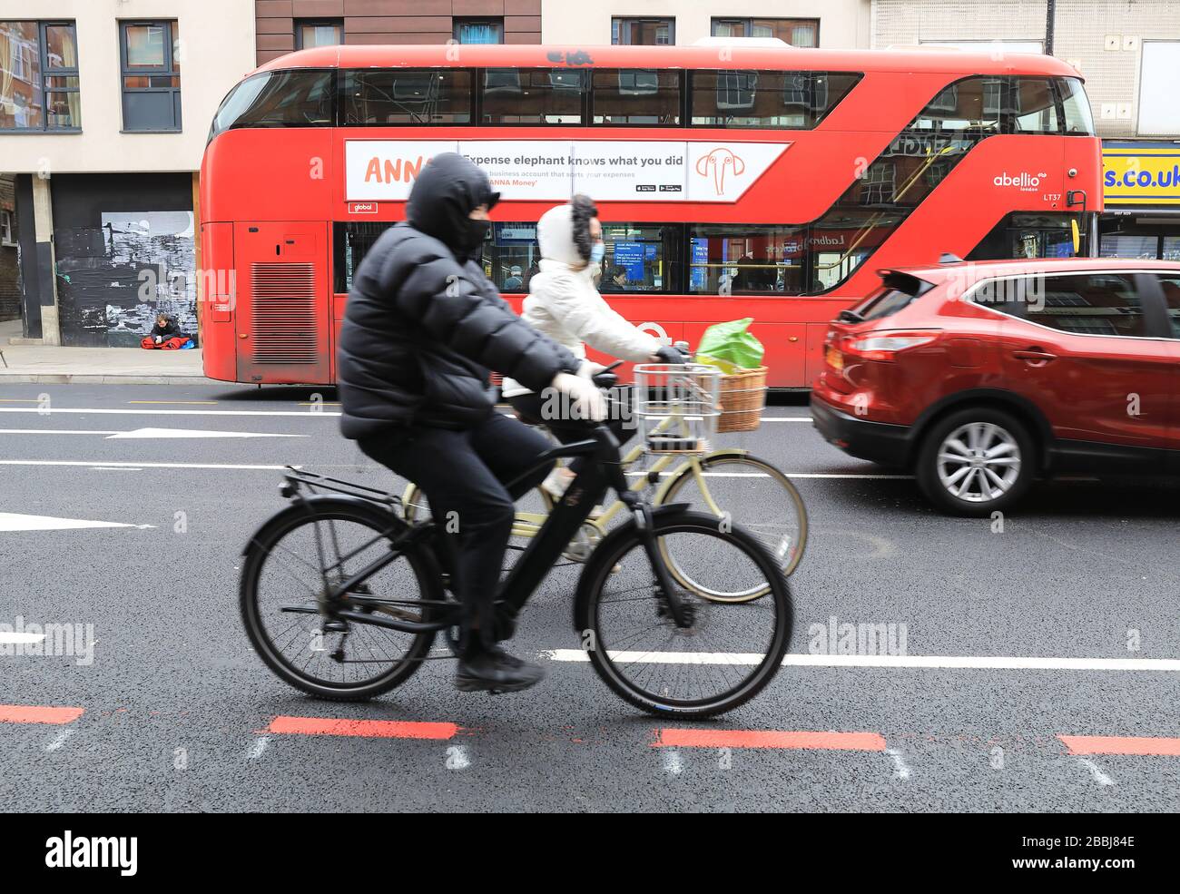 Radfahrer in Masken in der Coronavirus-Pandemie an der Camden High Street im Norden Londons, Großbritannien Stockfoto