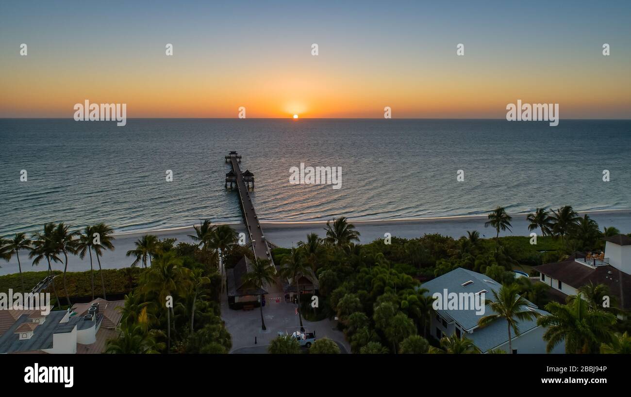 Leere Strände in Neapel Florida mitten in der Frühlingspause und Hauptsaison wegen Corona Virus Covid - 19. In der Regel sind diese Golfstrände mitten in der Hochsaison voller Touristen. Dies ist der Naples Pier bei Sonnenuntergang von einer Drohne aus. Dies ist der Naples Pier bei Sonnenuntergang von einer Drohne aus Stockfoto