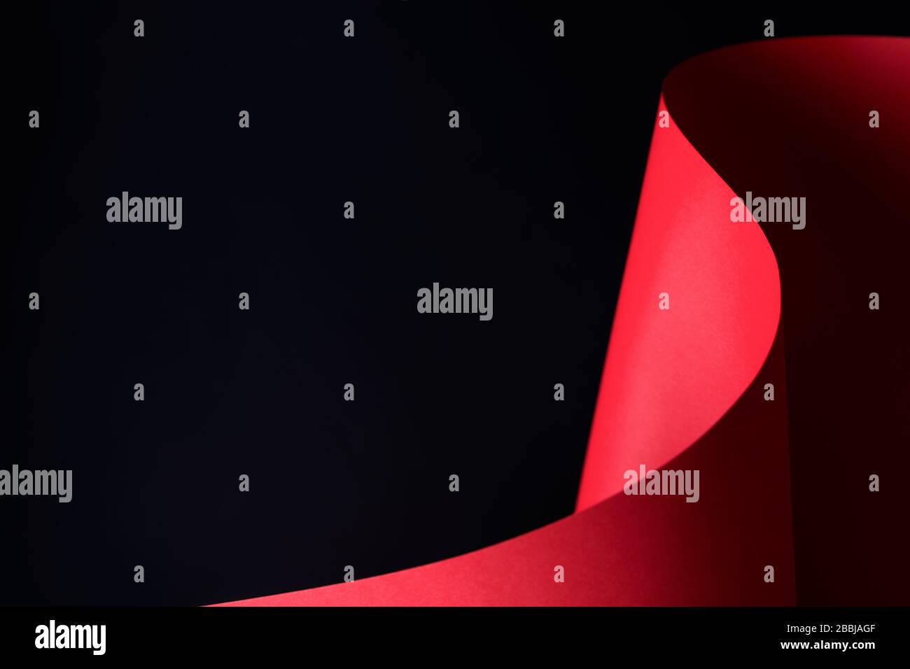 Rotes, gewelltes Papierhandwerk auf schwarzem Hintergrund - Nahaufnahme. Stockfoto