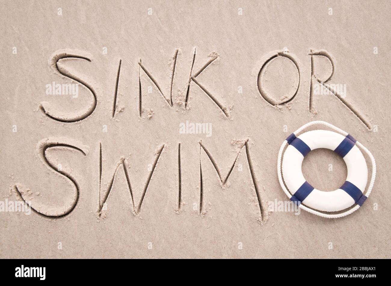 Spüle oder schwimmt die Nachricht handschriftlich am Strand mit Lebensrettern in glattem Sandkopierraum Stockfoto