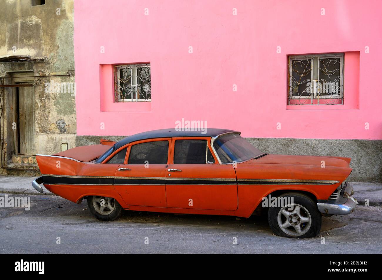 Rosa Wand mit altem rot-amerikanischem Fünfziger-Auto, Centro, Havanna, Kuba Stockfoto