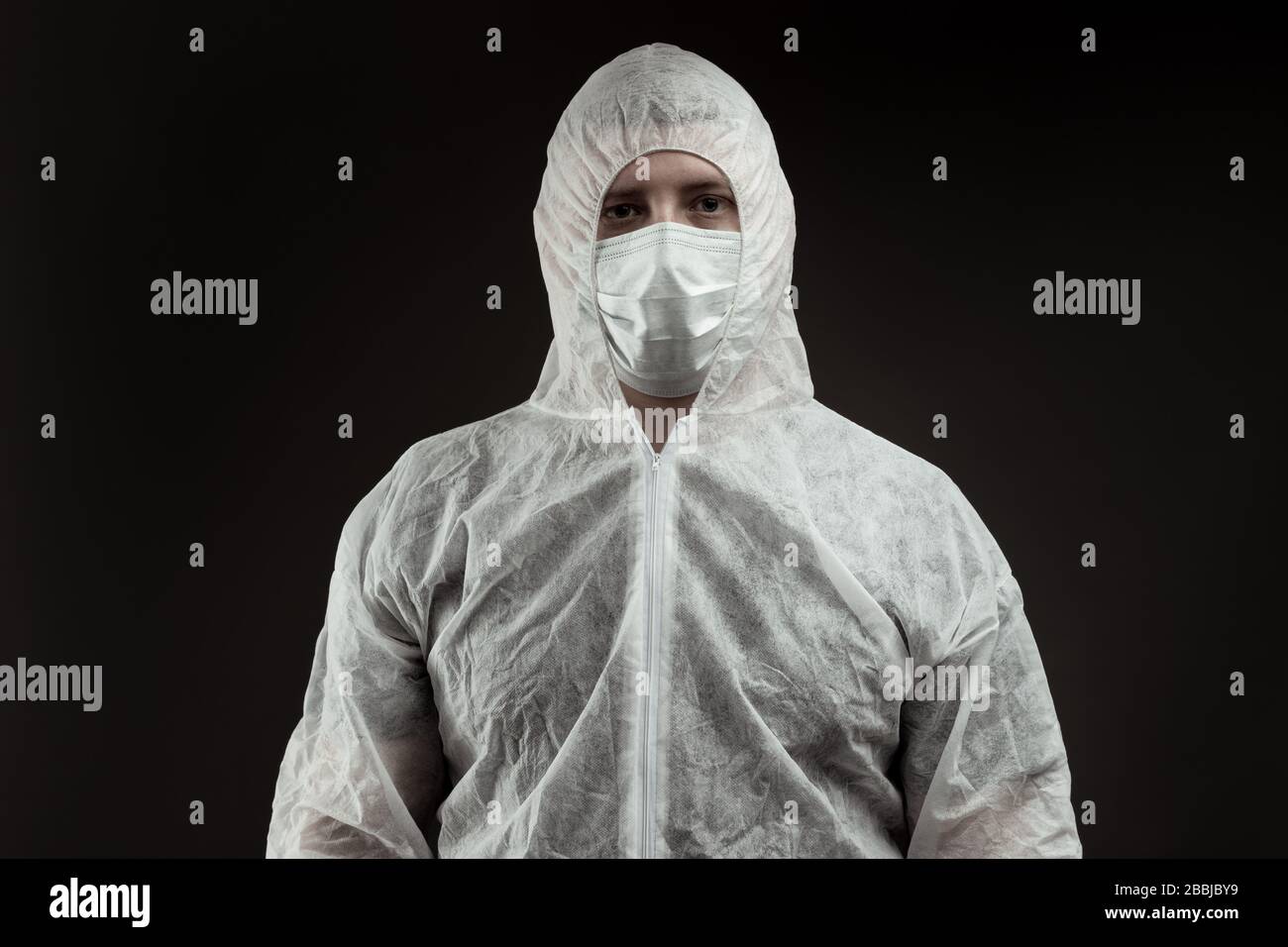 Porträt des Arztes im Schutzanzug vor schwarzem Hintergrund Stockfoto