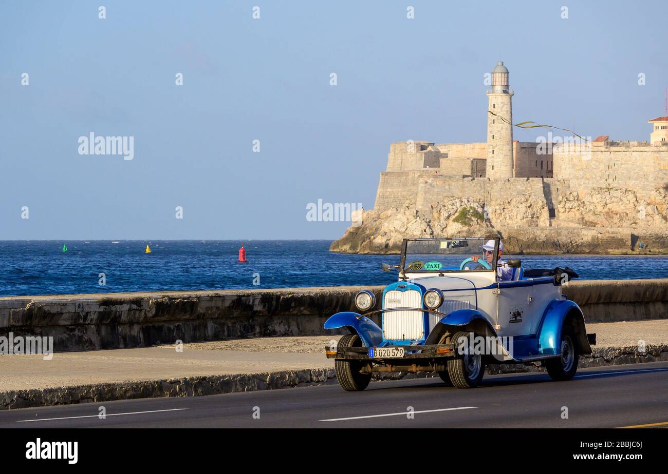 Oldtimer auf dem Malecon, mit Morro Castle Beyond, Centro, Havanna, Kuba Stockfoto