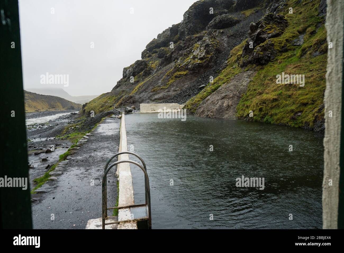 Leerer Seljavallalaug Swimmingpool mit strömendem Regen Stockfoto