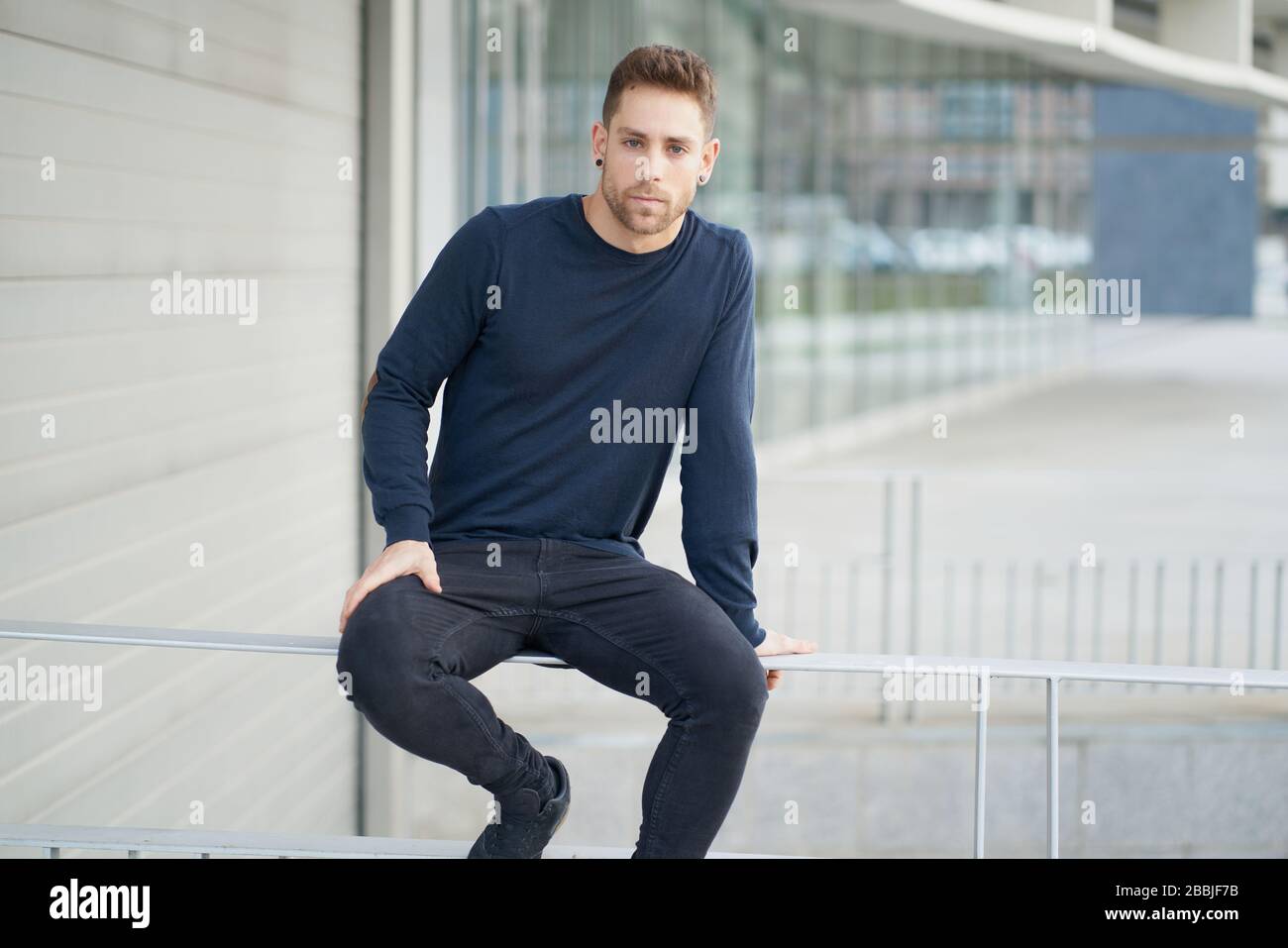 Niedriger Winkel der modernen Millennial männlich in lässigem Outfit mit Laptop Tasche l Stockfoto