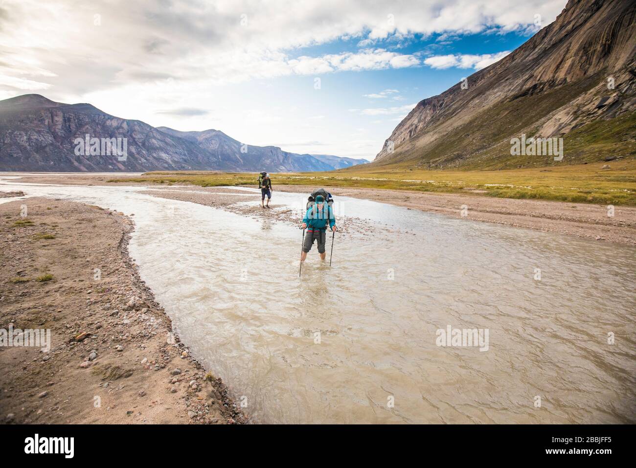 Zwei Backpacker überqueren den Fluss auf Baffin Island. Stockfoto