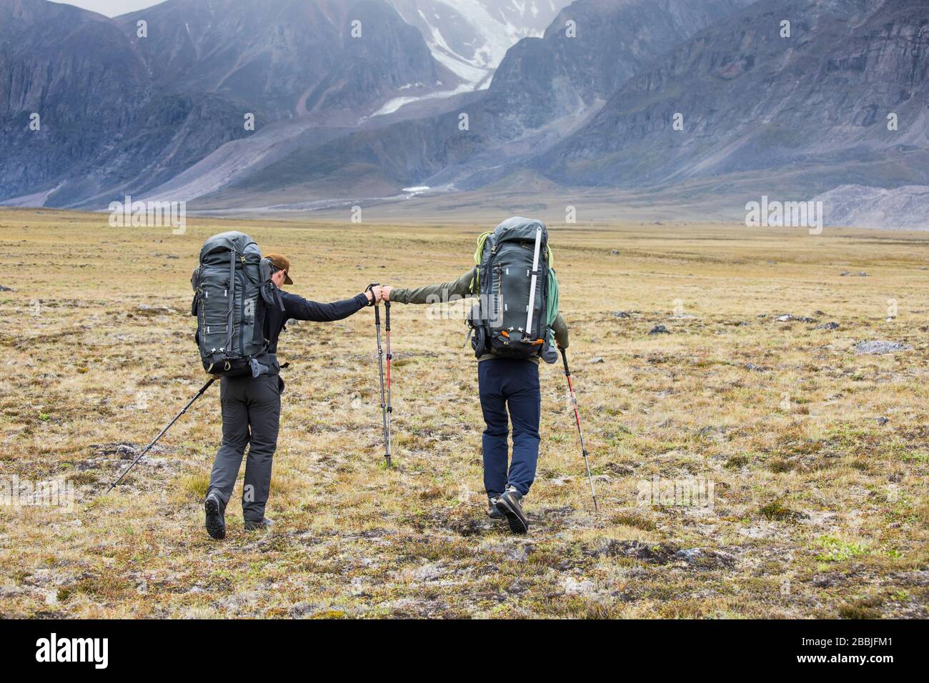 Zwei Rucksacktouristen (Freunde) stoßen bei der Fahrt über den arktischen Pass auf die Faust Stockfoto