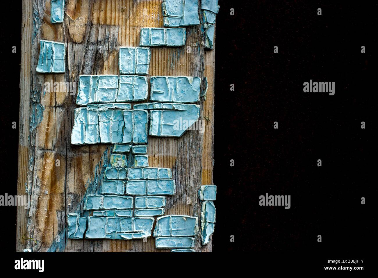 Ein Teil der alten Holzbretter, die in hellblau gesprungener Farbe mit mehreren Schichten geschelzter Lackteile lackiert sind Stockfoto