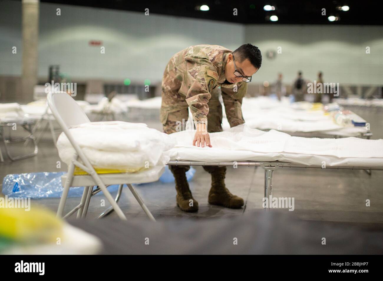 U.S. Air Force Tech. Sgt. Mario Lopez-Casas legt beim Einrichten einer Bundesärztestation Bettlaken auf ein Krankenhausbett, um bei der Pandemieentlastung des COVID-19-Coronavirus im Los Angeles Convention Center am 29. März 2020 in Los Angeles, Kalifornien, zu helfen. Stockfoto