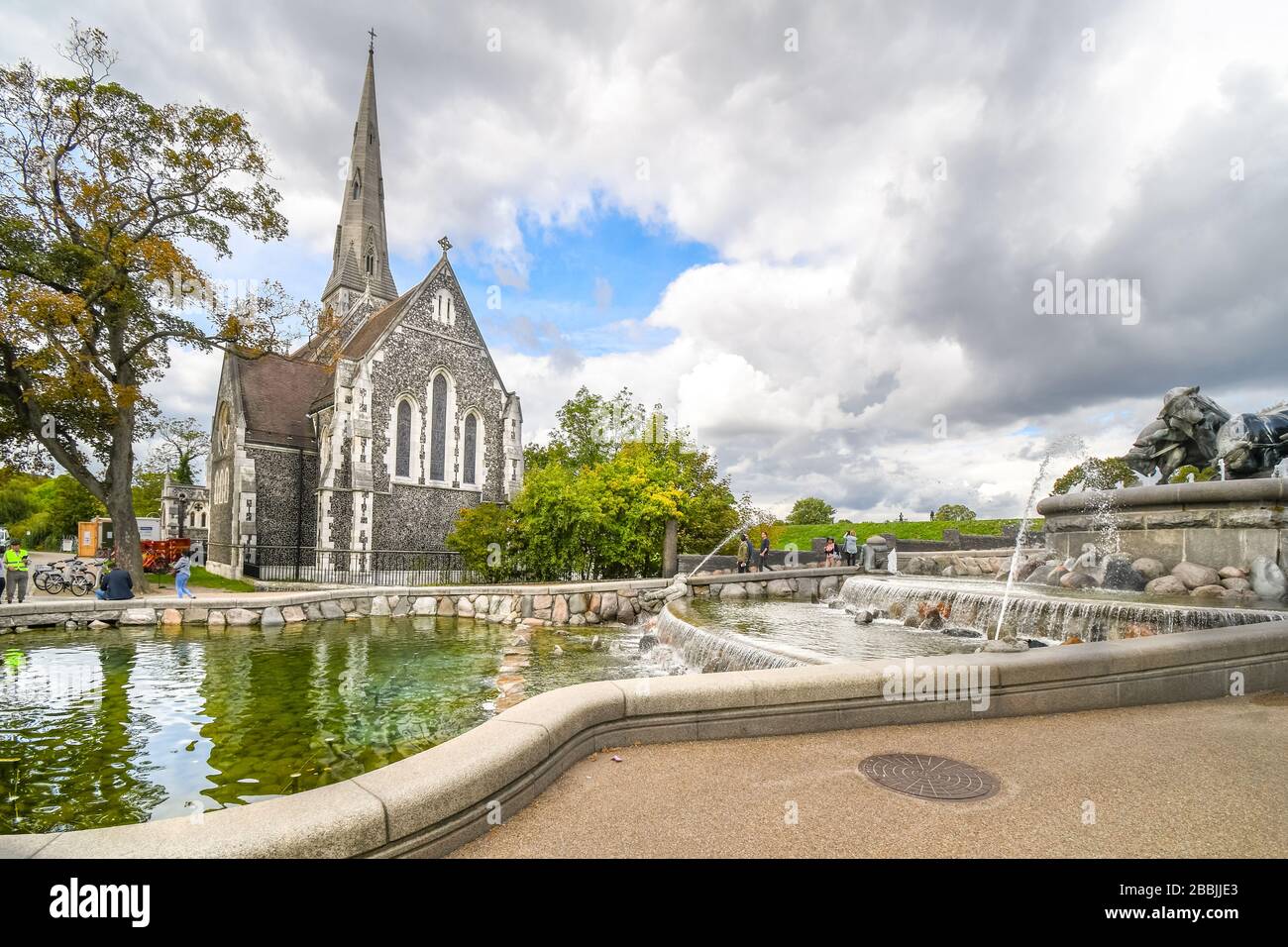 Touristen besuchen den Gefion-Brunnen und die englische St. Alban-Kirche in Kopenhagen, Dänemark Stockfoto