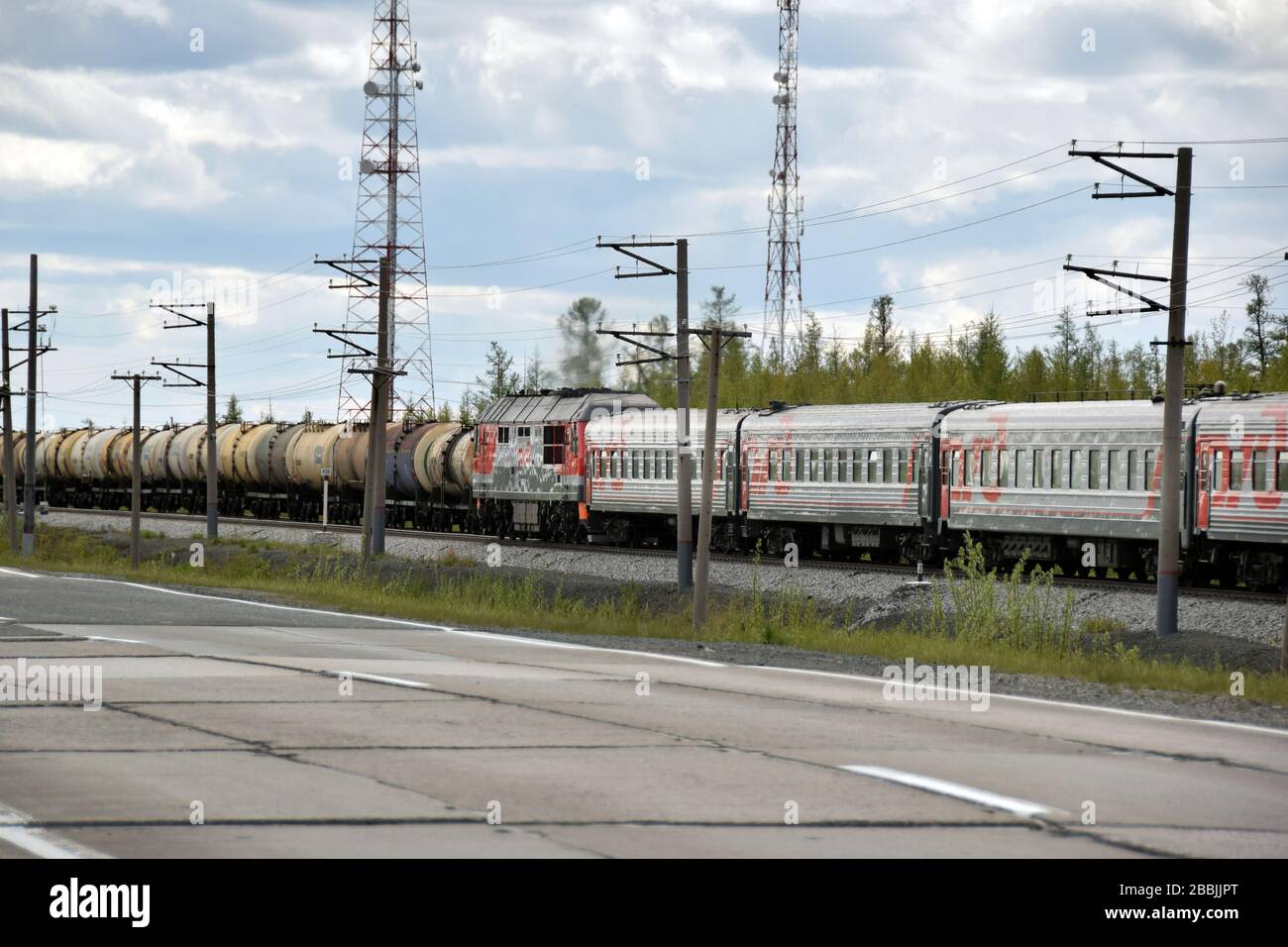 Ein Personenzug überquert einen Konvoi von Öltanks in der Nähe der Stadt Tarko-Sale in den Yamalo-Nenets autonomen territory.northern Russland. Stockfoto