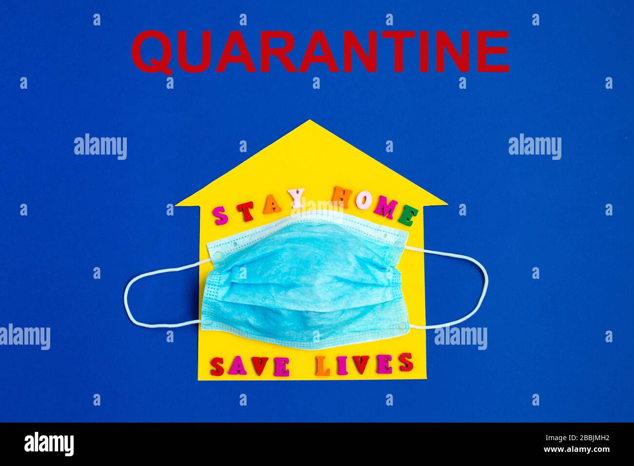 Quarantäne. "Stay Home Save Lives"-Ausdruck auf dem gelben Hintergrund und der Einwegmaske. Stockfoto