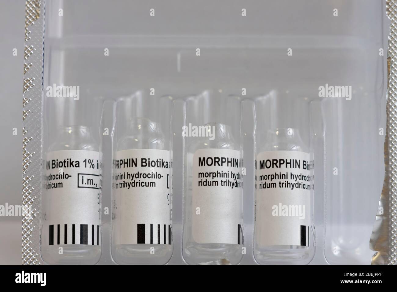 Gebrauchte Fläschchen mit injizierbarem Lösungsmorphium in einer Schachtel. Morphin ist ein starker Schmerzmittel und reduziert die Wahrnehmung von Dyspnoe Stockfoto