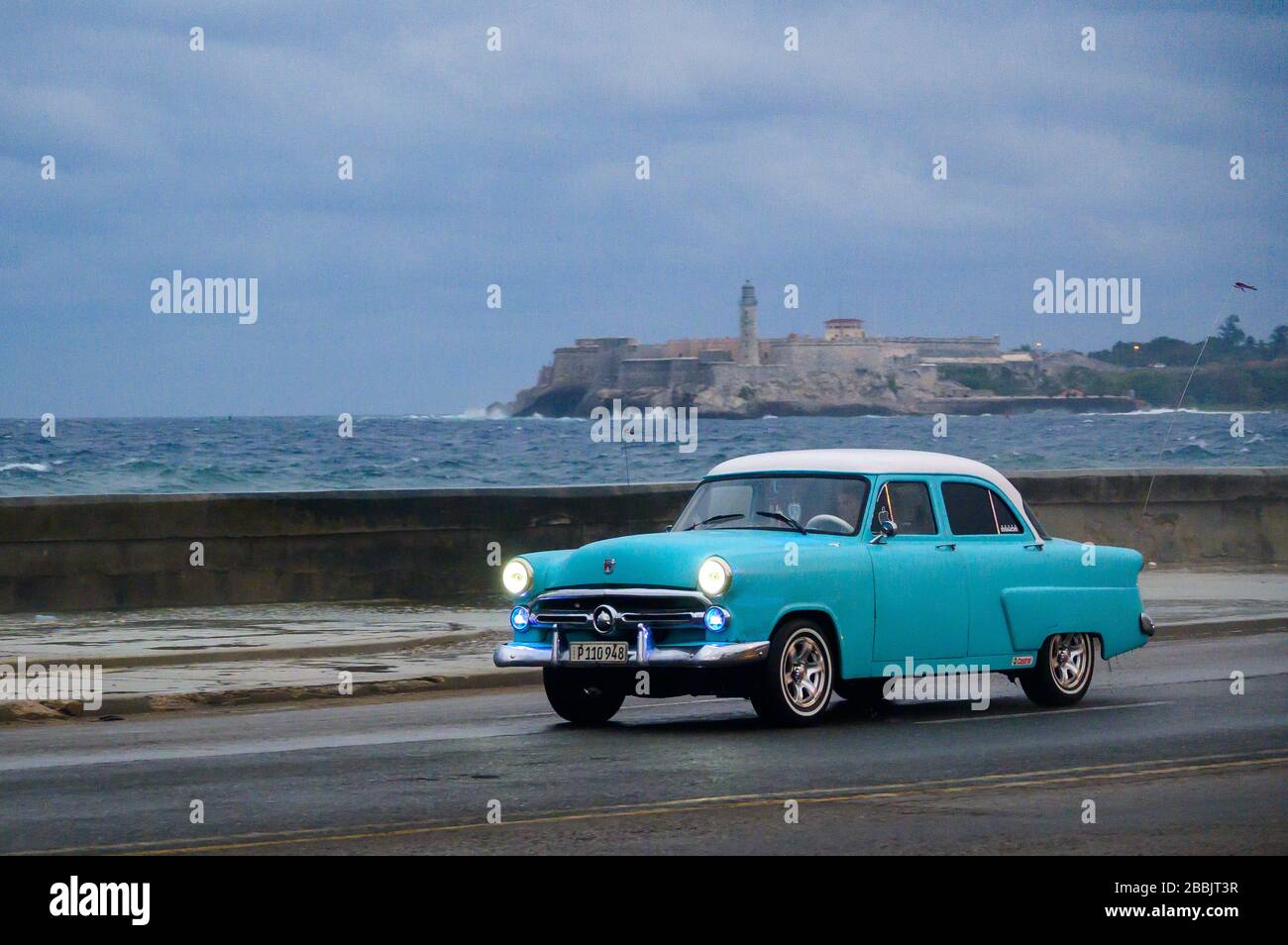 Classic Ford, auf dem Malecon, mit Morro Castle Beyond, Centro, Havanna, Kuba Stockfoto