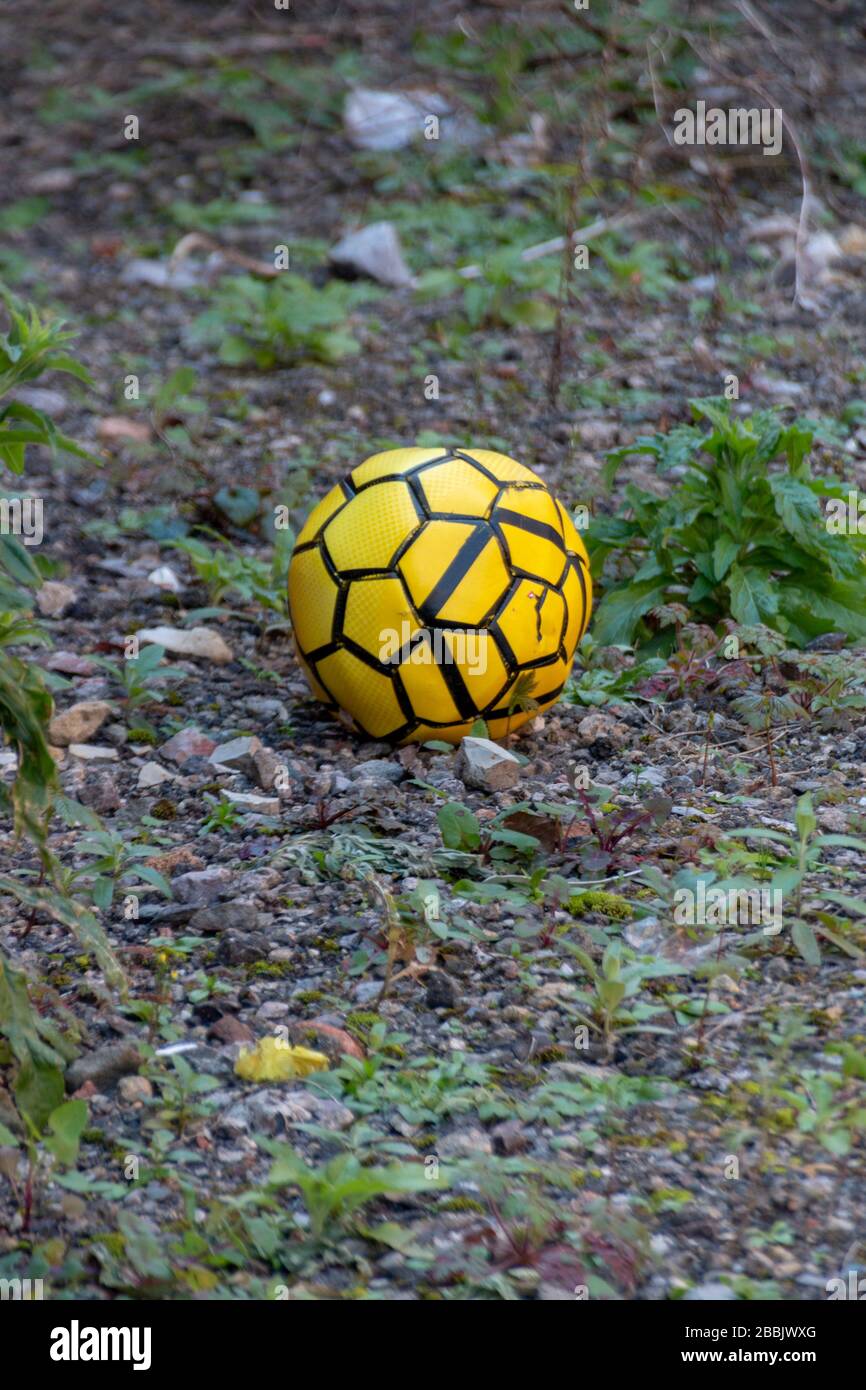 Bristol-Marhc 2020-England - eine Nahansicht eines leuchtend gelben und schwarzen Soccor-football, der in einem Hinterhofbereich zurückgelassen wurde Stockfoto