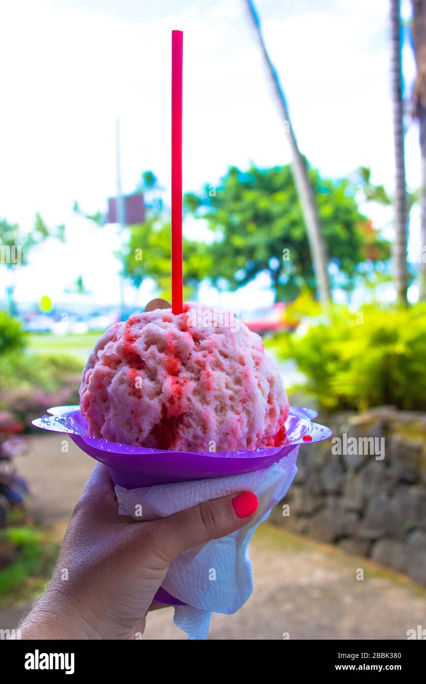 Eine Frau, die eine Erdbeere hawaiianische rasierte Eisdessert hält Stockfoto