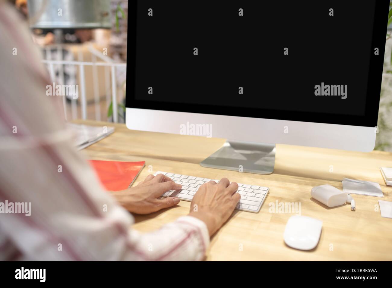 Weibliche Hände, die auf der Tastatur vor dem Bildschirm tippen Stockfoto