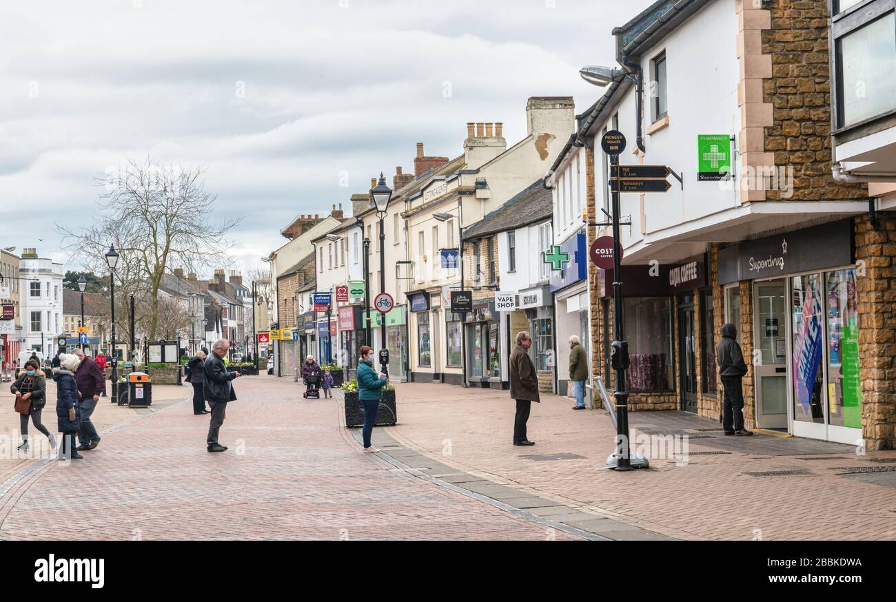 Bicester, Oxfordshire, Großbritannien März 2020. Käufer bilden gestaffelte Warteschlangen, um den sozialen Distanzierungsmaßnahmen zu entsprechen. Coronavirus pandemic.UK Lockdown Stockfoto