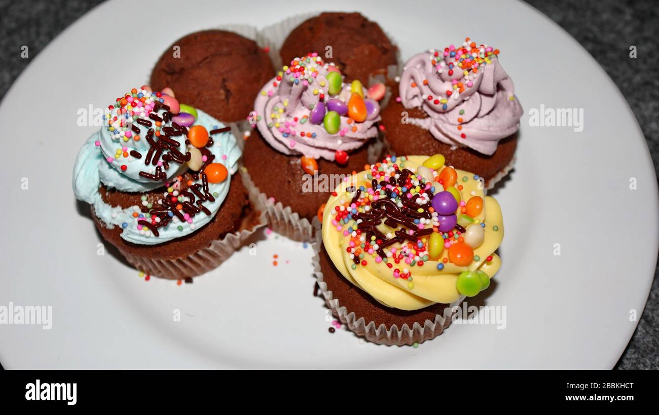 Nahaufnahme verschiedener süßer Cupcakes, selektiv fokussiert, vor einem bokehen Hintergrund Stockfoto