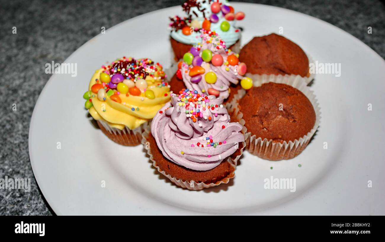 Nahaufnahme verschiedener süßer Cupcakes, selektiv fokussiert, vor einem bokehen Hintergrund Stockfoto