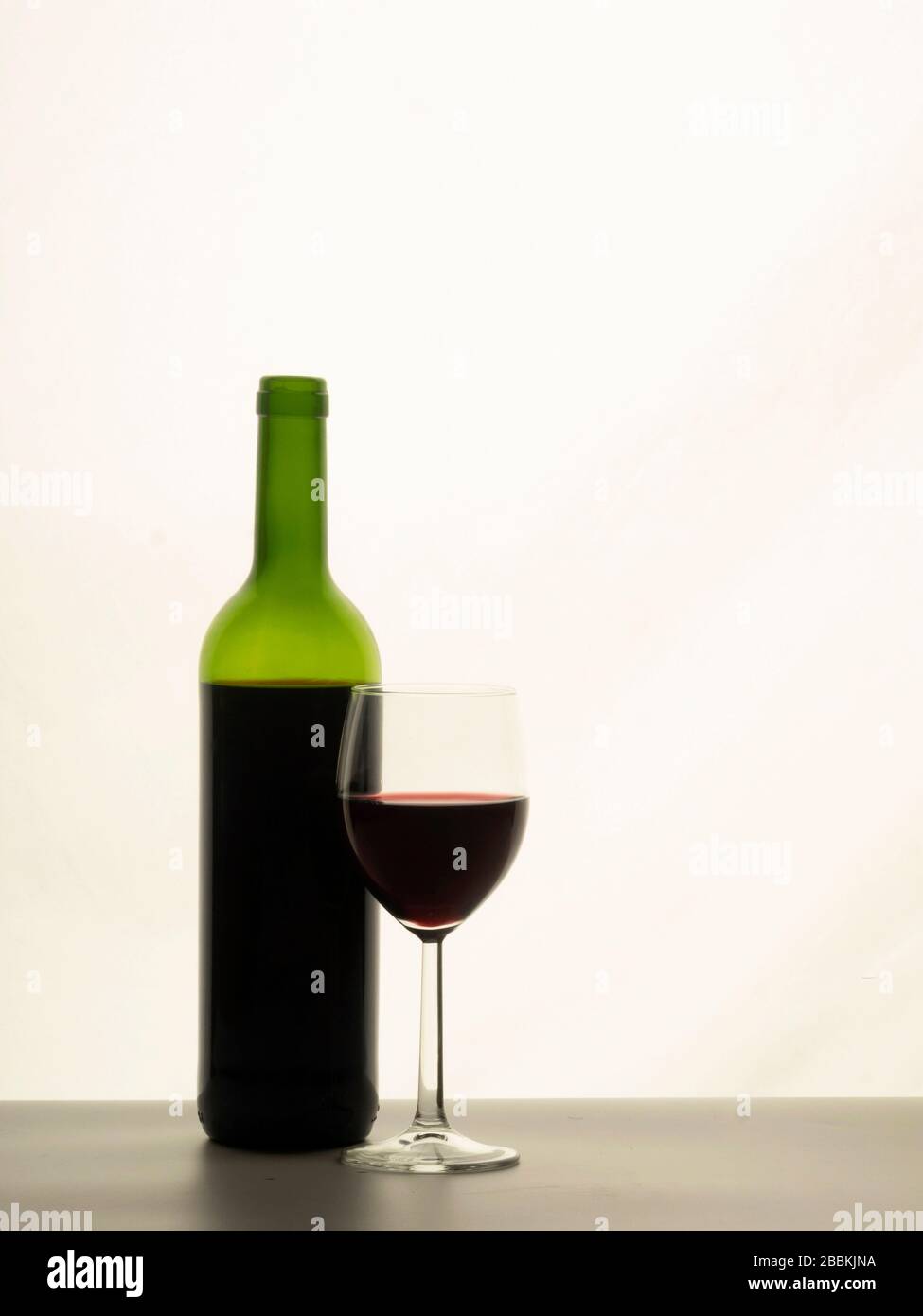 Nahaufnahme von Rotweinglas mit Flasche Stockfoto