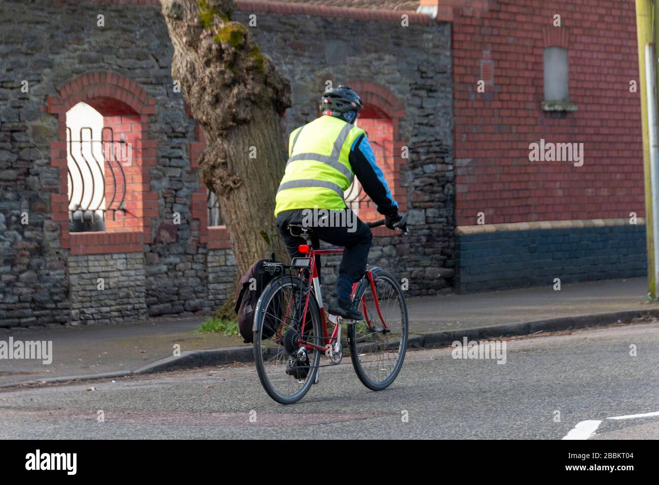Bristol-März 2020-England - EINE Nahansicht eines Mannes, der mit seinem Fahrrad zum Laden fährt oder an einem kalten Sommermorgen arbeitet Stockfoto