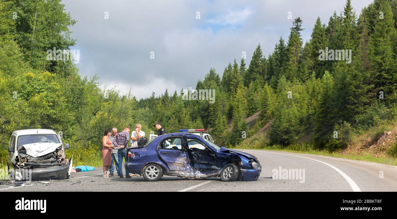 Svalyava, Ukraine. 11. August 2019: Tödlicher Verkehrsunfall. Reales Ereignis. Zwei Autos sind auf der Straße abgestürzt. Der Polizist verhört Teilnehmer und Witz Stockfoto