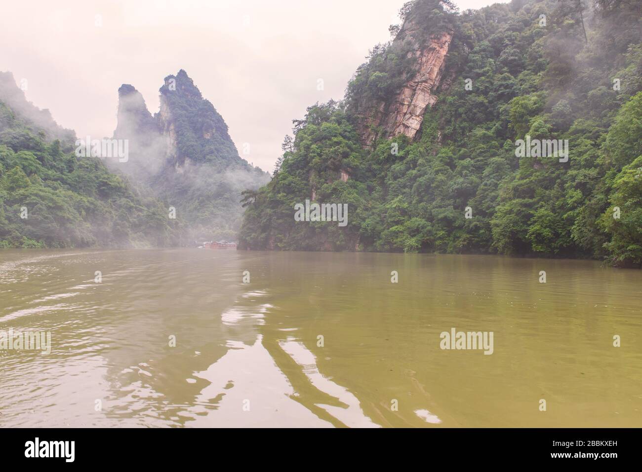 Bootsfahrten auf dem Baofeng See Landschaft mit üppigen Wald rund um die hohen Steingipfel in Wulingyuan landschaftlich reizvolle Gegend in der Nähe Zhangjiajie, Provinz Hunan, China Stockfoto