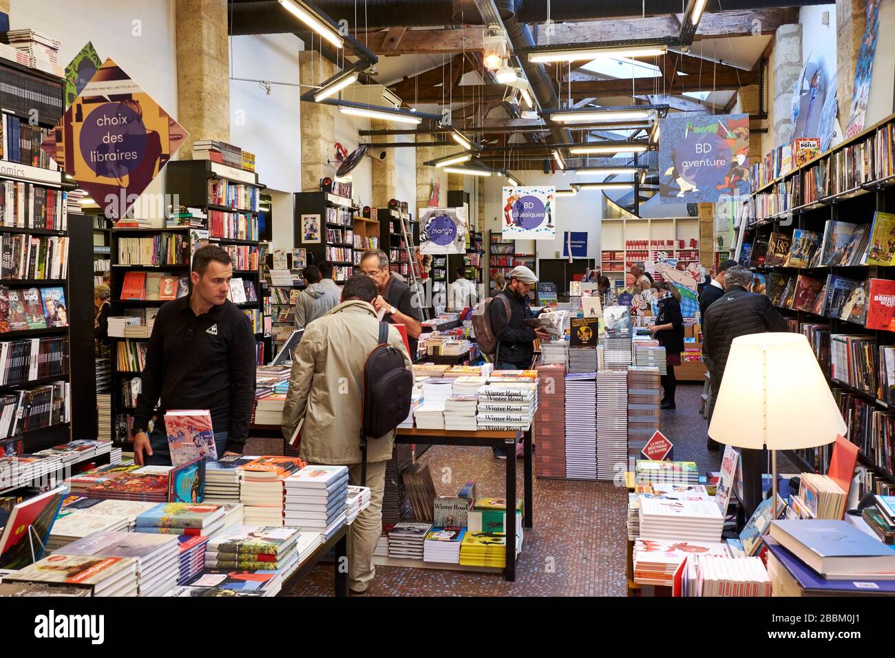 Innenansicht der Librarie Mollat in Bordeaux, der größten unabhängigen Buchhandlung Frankreichs mit Kunden, die die Bücherregale durchsuchen Stockfoto