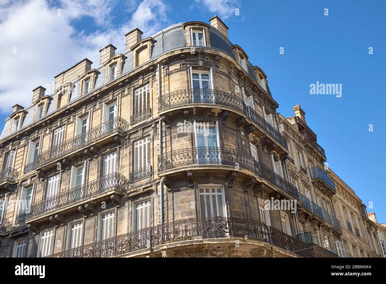 Traditionelles Apartmentgebäude mit Metallbalkons und Fensterläden im Stadtzentrum von Bordeaux Stockfoto