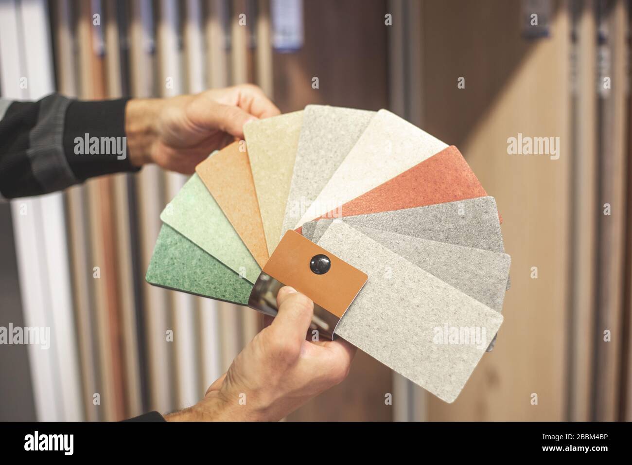 Der Mann, der die richtige Farbe und das richtige Material für seine neue Wohnung im Studio auswählt und Haushalte ausstellt Stockfoto