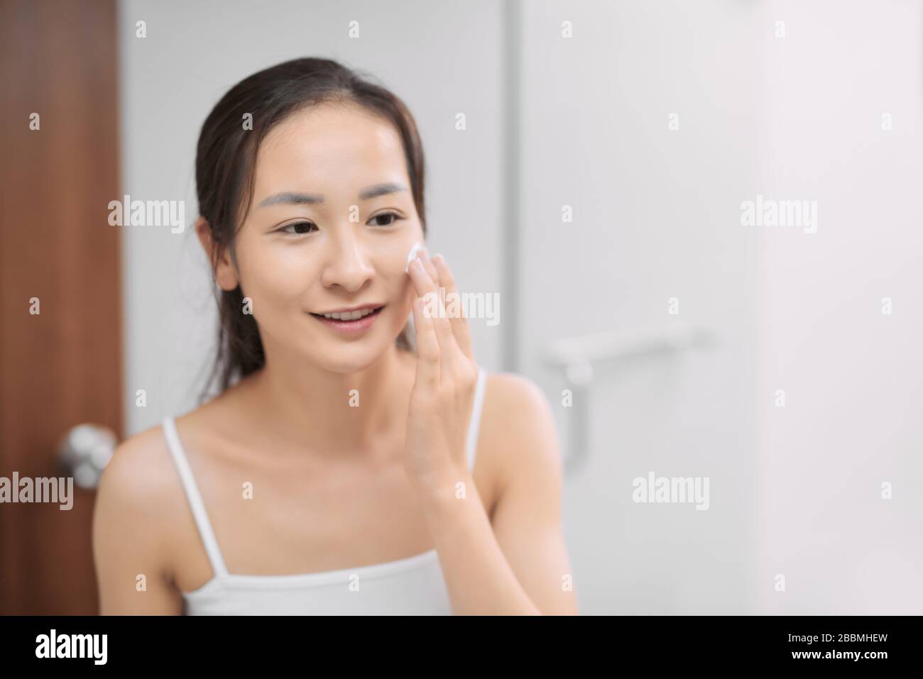 Hautpflegefrau waschen Gesicht in Dusche schäumendes Gesicht Seifenspülung auf der Haut. Genießen Sie erholsame Zeit Stockfoto