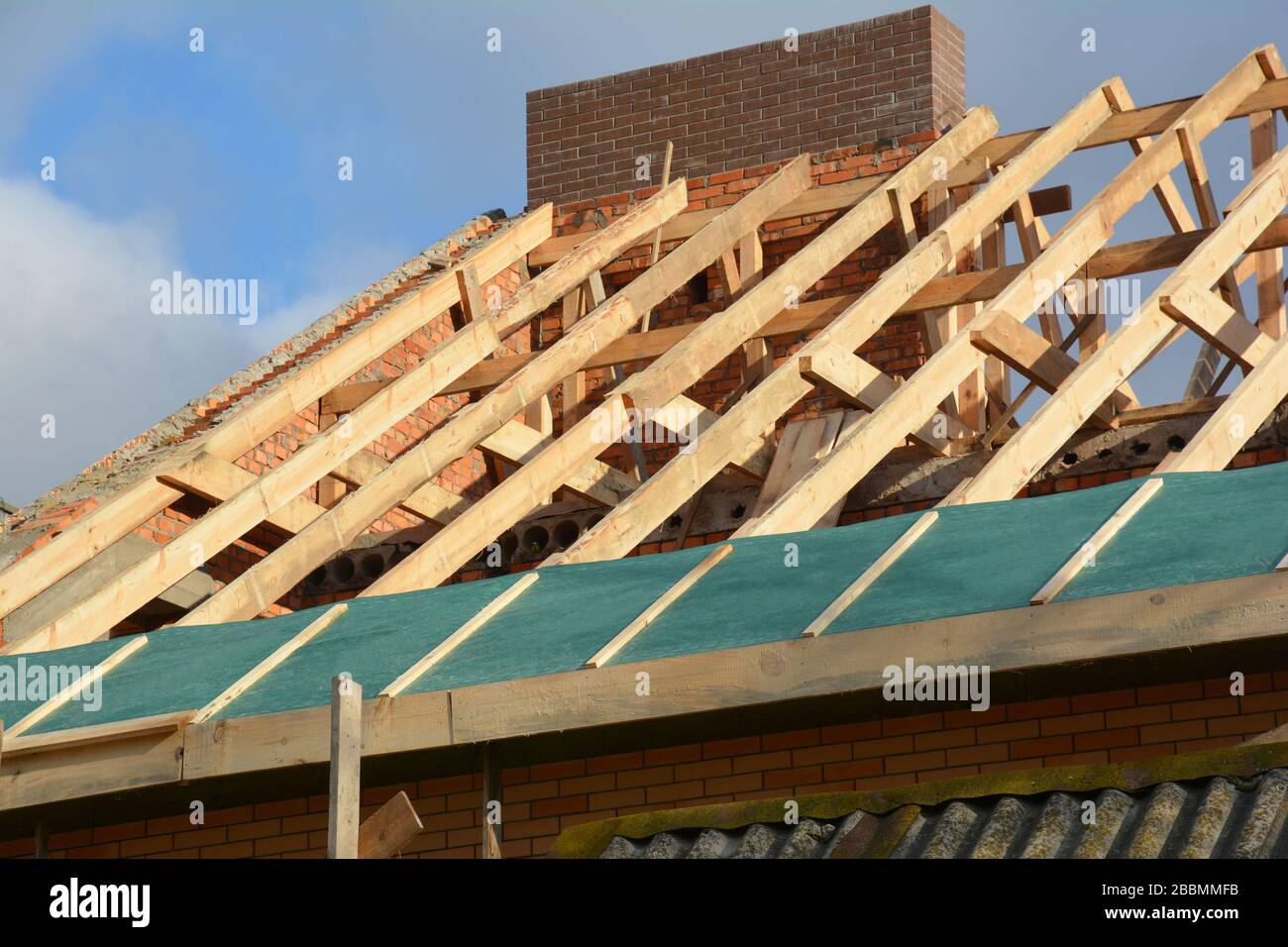Holzrahmenkonstruktion auf dem Dach. Unvollständige Dachdachkonstruktion, Trassen, Dampfsperre, Holzbalken, Traufen, Holz. Stockfoto