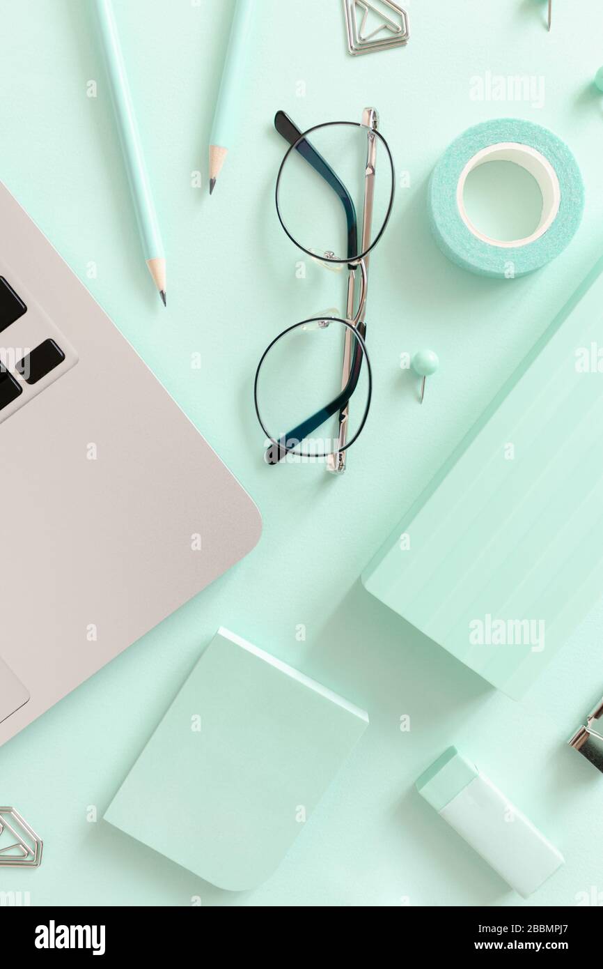 Komposition mit Laptop, Brille und Schreibwaren auf dem Minztisch Stockfoto